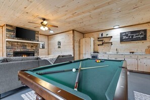 Billiard table in the Game Room with a full wet bar, secondary living space with another fireplace and smart TV. Enjoy drinks, the big game, and some pool with friends.