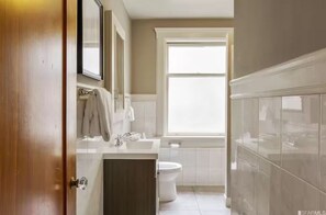 Sparkling clean shared full bathroom with bathtub.
