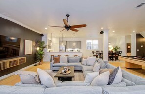 Offering an atmosphere of timeless elegance, this living room features an oversized U-shaped sectional for plenty of seating space and a large wall-mounted TV.