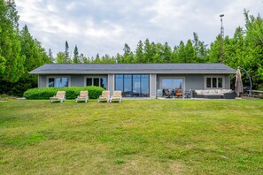 The Georgian is a very large ranch style 2,600 sq. ft. bungalow. Everything you need is accessible at your fingertips. This is a view from the North lawn looking towards the patio and grassy knoll loungers. 