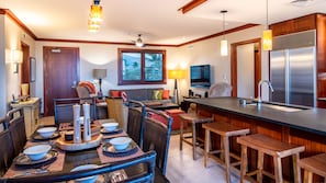 A Roy Yamaguci designed kitchen with stainless steel appliances and a cozy living room area.