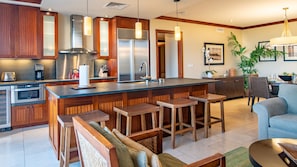 A well equipped kitchen with stainless steel appliances and bar seating.