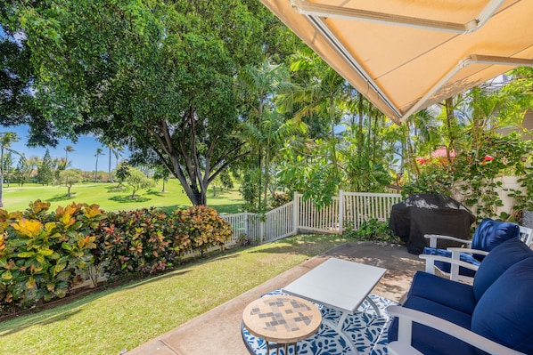 Seating on the lanai surrounded by lush greenery.