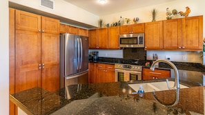 The kitchen features stainless steel appliances and numerous amenities.