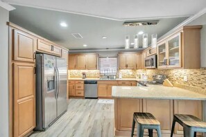 Stocked kitchen with coffee machine, blender, crockpot, toaster, utensils, etc