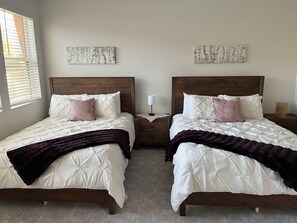 Master bedroom has 2 queen beds and a TV. 