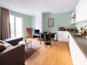 Open plan lounge with sofa, dining , and fully equipped kitchen