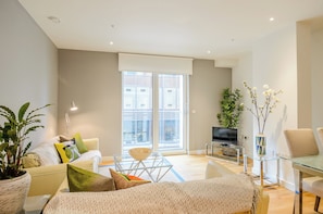 Open plan lounge with sofa, dining , and fully equipped kitchen