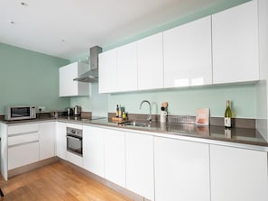 Open plan lounge with sofa, dining , and fully equipped kitchen