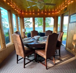 Guests can relax in the three season sunroom with a card/billiard table that has a top that flips to a dining table.  Two doors lead to the river-side deck/grill and the covered back porch.