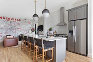 Clean and Spacious Kitchen with Sleek Countertops and Additional Seating