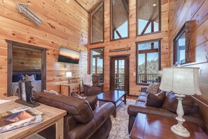 Comfortable living room with floor to ceiling windows. Also a smart TV on the wall for watching the big game on the weekend. You might even take a nap on these relaxing leather chairs and couches.