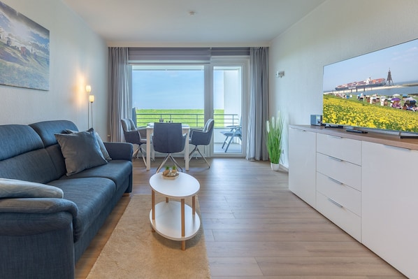 Wohnbereich mit Sofa und großem TV.