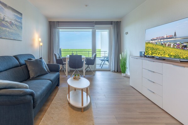 Wohnbereich mit Sofa und großem TV.