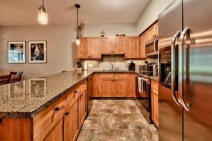 Kitchen well stocked with small appliances, induction cooktop and dual oven
