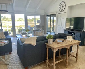 View of LR ( w/ wine bar behind bifold doors) looking back over the tidal marsh