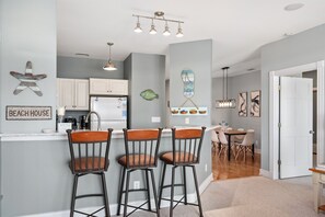 A charming and inviting kitchen beckons with its chic bar stools and elegant dining table