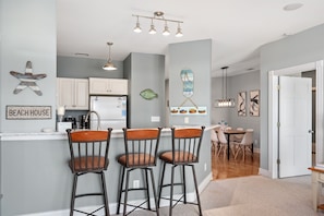 A charming and inviting kitchen beckons with its chic bar stools and elegant dining table