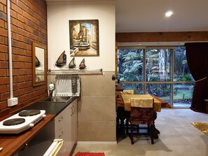 Kitchen area comes with dimmable lighting, extractor fan, two plate cooktop, and microwave.