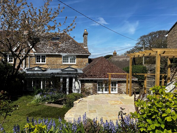 East Cottage, Langton Herring, Weymouth: Bluebells frame the pretty garden during the spring time