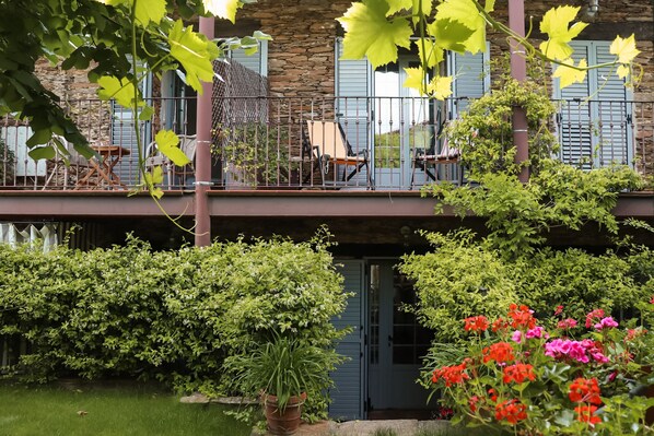 fachada trasera de la casa principal tomada desde la terraza con pérgola. 