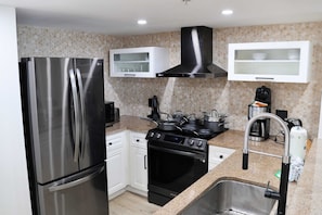 New Kitchen with Black stainless steel appliances, vented hood, induction cooktop w/air fryer, microwave, toaster, all utensils and more.