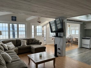 Living room, dining, and kitchen with access to beachside deck.