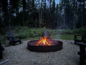 Large fire pit with Adirondack chairs