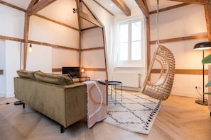 The living area has a TV, and the large window lets in plenty of natural light