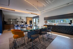 Modern eingerichtetes Wohnzimmer mit zwei bequemen Sofas und einer voll ausgestatteten Küche im Hintergrund