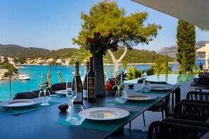 Ein reich gedeckter Tisch auf der Terrasse der dalmatinischen Luxusvilla Aman Korcula mit bezauberndem Blick auf das Meer