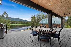 Large patio with dining table, swing, and bbq grill