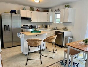 Bright kitchen with 2 bar seats and dining table seats 4