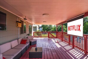An outdoor movie theater with free movies/tv shows with comfy seating and heater