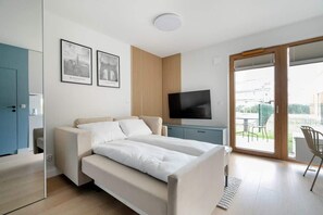 A stylish bedroom with a large bed, blue wardrobes, and a wooden accent wall.


