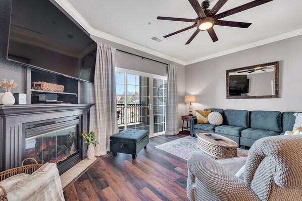 Inviting living room with soft sectional sofa and electric fireplace.