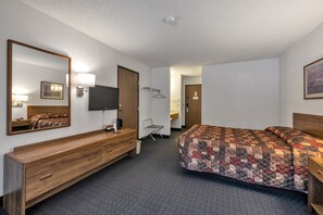 Experience comfort in this welcoming room featuring a lock-off option to an adjoining 2 Queen room, perfect for families or groups. It includes a Queen bed, sleeper sofa, and sitting area for relaxation. Indulge in the luxury of a one-person jetted bathtub, ideal for unwinding after adventures. A private toilet/sink area and a lobby microwave add to your convenience.