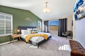 Spacious master's bedroom with TV and window with an expansive view