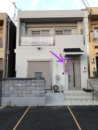 front view. Another house on the right side. concrete walls separate the two.