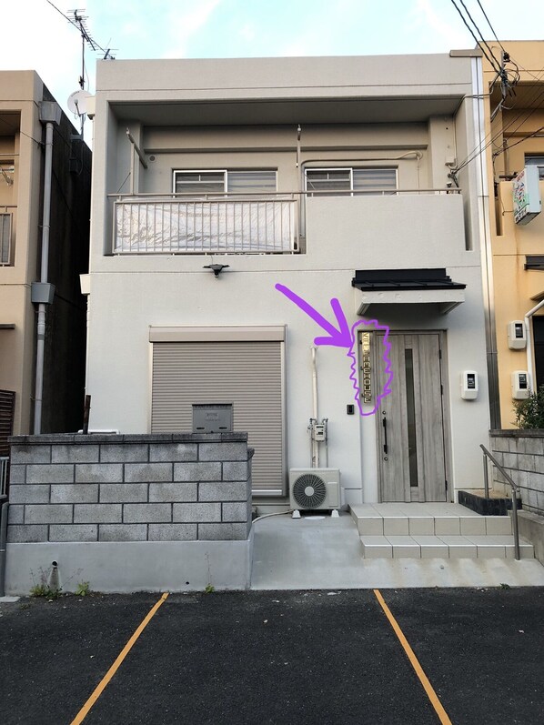 front view. Another house on the right side. concrete walls separate the two. 