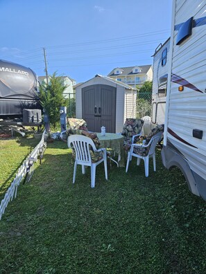 The outside area has a patio with 4 chairs and a table. 