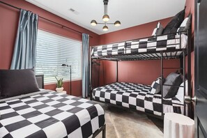 Bedroom #2 with Queen-over-Queen bunk beds, a Twin bed, a Smart TV with all the apps, and room-darkening shades. There's also a hanging space for you to keep your clothes.