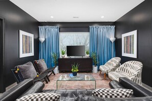 Comfortable living room with lots of seating, natural light, room-darkening shades, and a Smart TV with all the streaming apps.