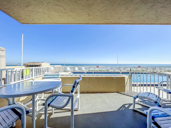 Relax on this private patio overlooking the pool and the serene ocean horizon, offering a perfect spot for outdoor dining and soaking up the coastal atmosphere.