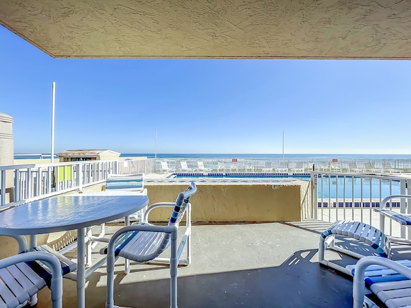 Relax on this private patio overlooking the pool and the serene ocean horizon, offering a perfect spot for outdoor dining and soaking up the coastal atmosphere.