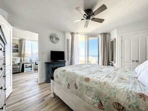 This cozy bedroom offers direct access to a private balcony with stunning ocean views, providing a relaxing retreat with beach-themed décor and modern comforts for a peaceful seaside escape.