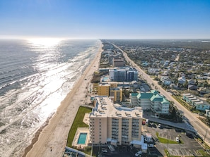 This aerial view showcases a beautiful beachfront property with sweeping views of the coastline. With easy access to the beach and nearby amenities, it's the perfect spot for a serene and relaxing coastal escape.