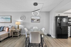 The dining area flows seamlessly into the adjacent living room and kitchen, offering an open-plan layout perfect for entertaining or casual meals.