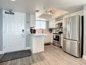 Bright kitchen with stainless steel appliances, sleek countertops, and easy access to living spaces.