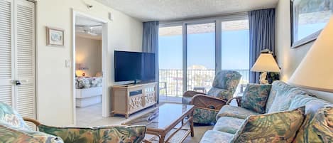 Comfortable seating with tropical accents and large windows showcasing stunning views.